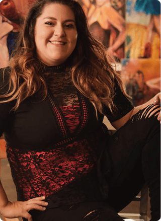 Brie, a Mastery Program mentor, in front of her paintings