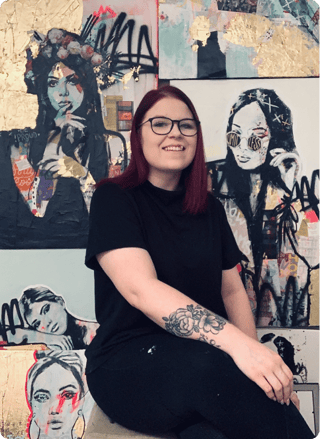 Tanya, a Mastery Program mentor, in front of her paintings