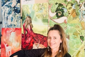 Tanya a femalke is sitting in front of her artwork of a woman in garden